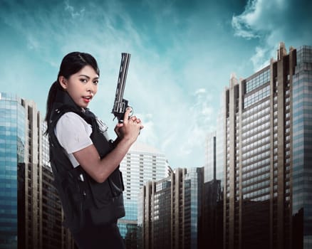 Beautiful police woman holding gun ready to fire