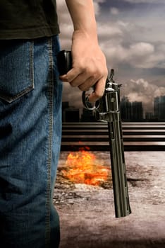 Man hand holding gun with burn city background