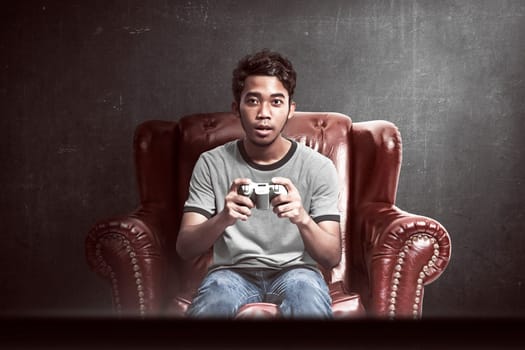 Portrait of asian man playing video games in his living room