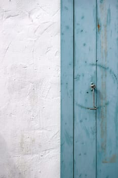 The neckline of an old wooden shutter with a hook.
