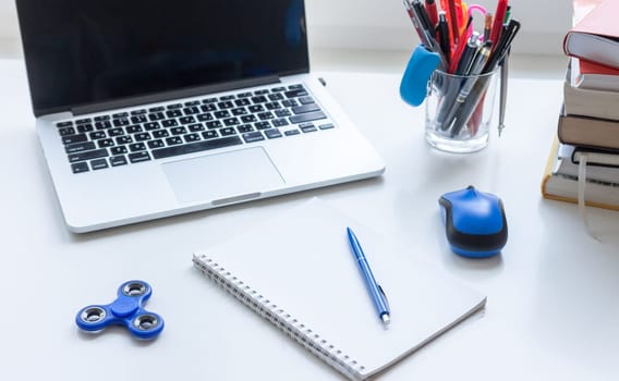 work desk with laptop mouse glasses and spinner