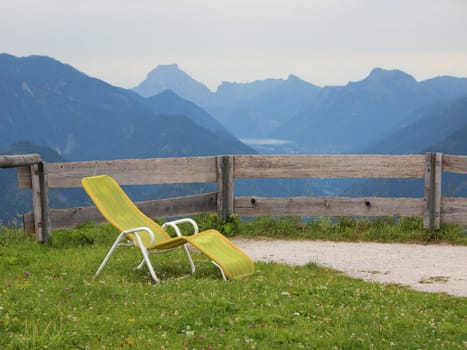 Yellow Sun Chair on Grass Lawn with Mountain Background View