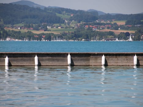 Wooden Pier with Five White Plastic Fenders Hanging on Side