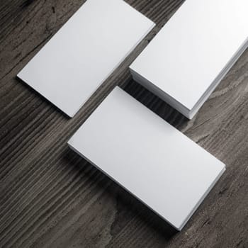 Stacks of blank business cards on wooden background.
