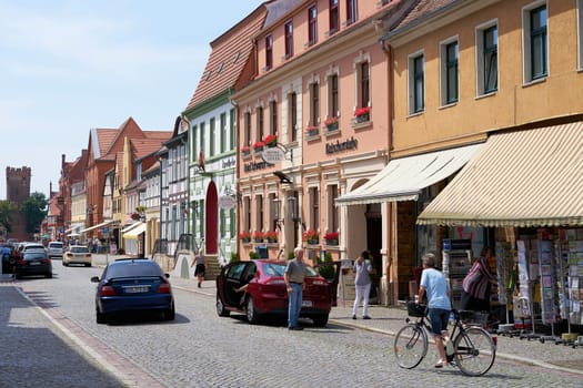 historic buildings and passers-by in a shopping street in Tangermünde