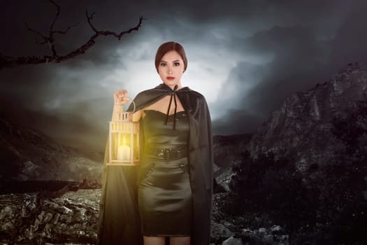 Asian witch woman with a lantern walking on rock hill