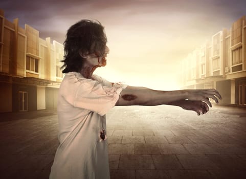 Horrible male zombies walking around the city at sunset