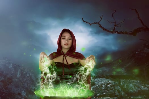 The charming asian witches woman preparing a potion with magic in the cauldron