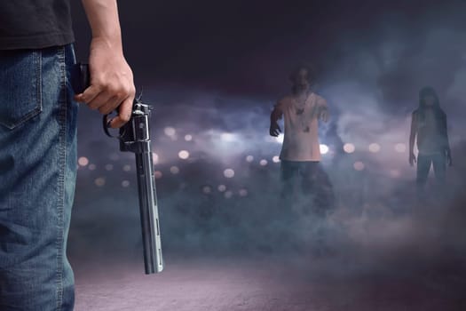 Brave man with jeans pants holding gun looking at zombies walking into him