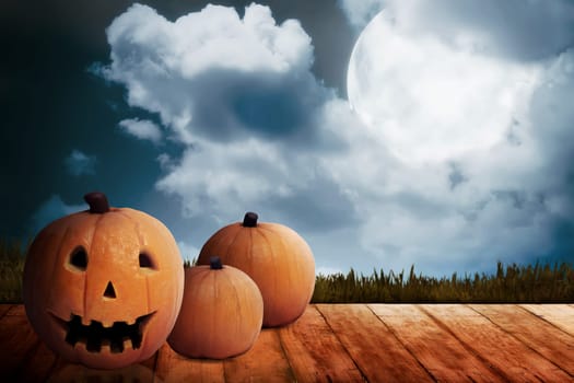Three Jack O'Lantern on the wooden floor. Halloween concept
