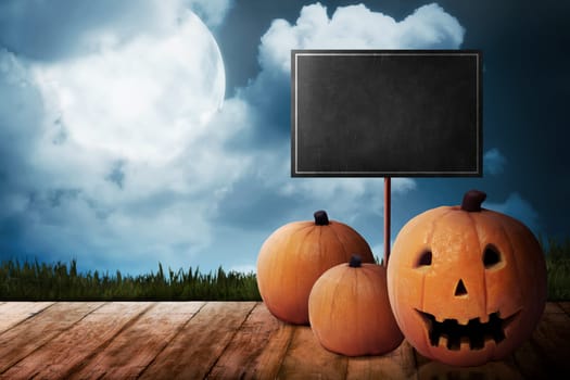 Three Jack O'Lantern on the wooden floor. Halloween concept. You can put your message on the board