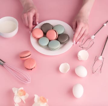 The female hands with cookies with cream on pink background