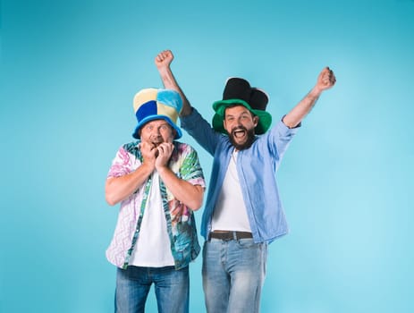 The two emotional football fans over blue background