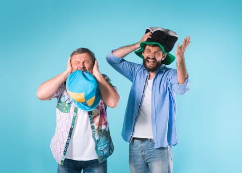 The two football fans singing the national anthem over blue background