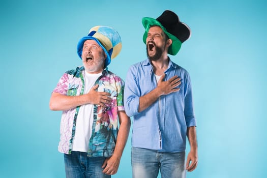 The two football fans singing the national anthem over blue background