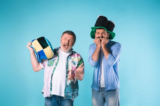 The two emotional football fans over blue background