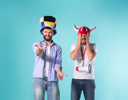 The two football fans with emotions of disappointment over blue background