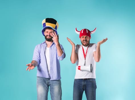 The two football fans with emotions of disappointment over blue background