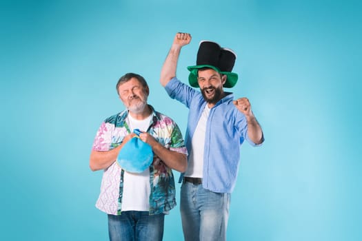 The two emotional football fans over blue background