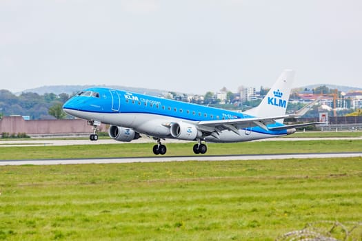 Stuttgart, Germany - April 29, 2017: Airplane Embraer ERJ-175 from KLM cityhopper during landing - green meadow in front