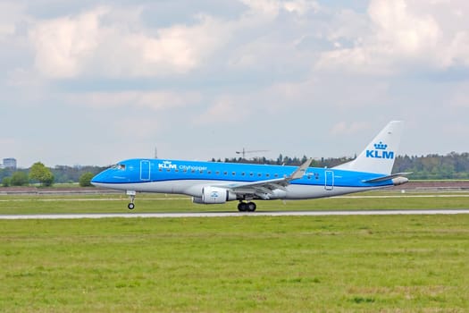 Stuttgart, Germany - April 29, 2017: Airplane Embraer ERJ-175 from KLM cityhopper during landing - green meadow in front