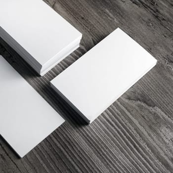 Photo of blank paper business cards on wooden background.