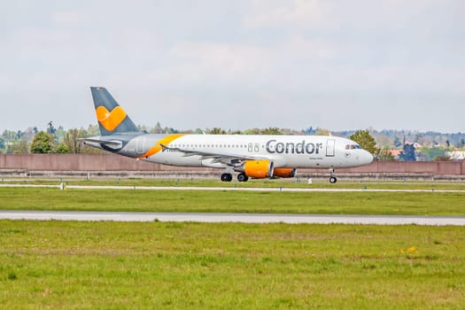 Stuttgart, Germany - April 29, 2017: Airbus airplane A320 from Condor at ground (airport Stuttgart) before take off - green meadow with fence in front