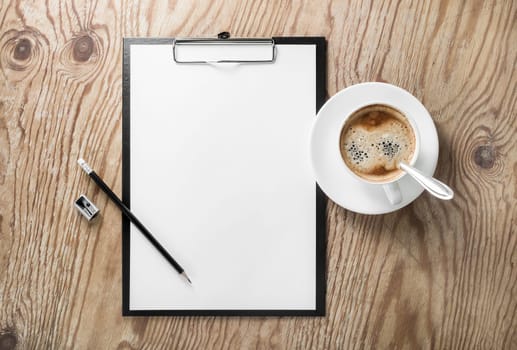 Clipboard with blank letterhead, coffee cup, pencil and sharpener on wooden background. Responsive design template. Top view.