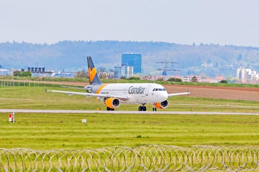 Stuttgart, Germany - April 29, 2017: Airbus airplane A320 from Condor at ground (airport Stuttgart) before take off - green meadow with fence in front