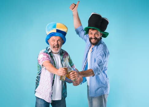The two emotional football fans over blue background with beer