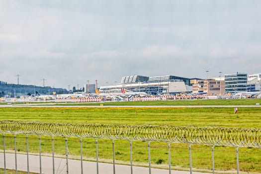 Stuttgart, Germany - May 06, 2017: Airport Stuttgart (Manfred-Rommel-Flughafen), Terminal, exterior view with airplanes in parking position, runway in front