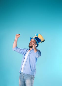 The emotions on face of football fan with hat over blue background