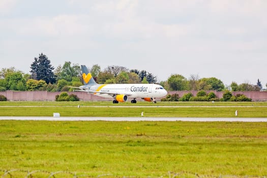 Stuttgart, Germany - April 29, 2017: Airbus airplane A320 from Condor at ground (airport Stuttgart) before take off - green meadow with fence in front