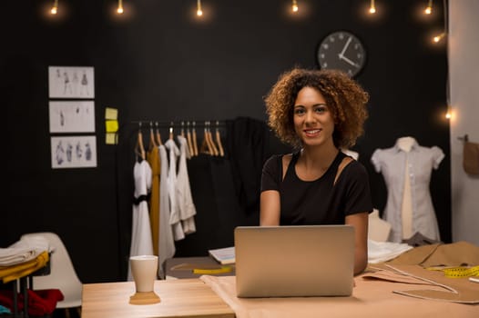Portrait of a young fashion designer working on her atelier