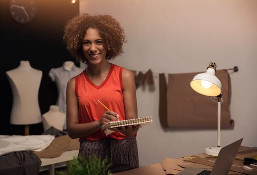 Portrait of a young fashion designer working on her atelier