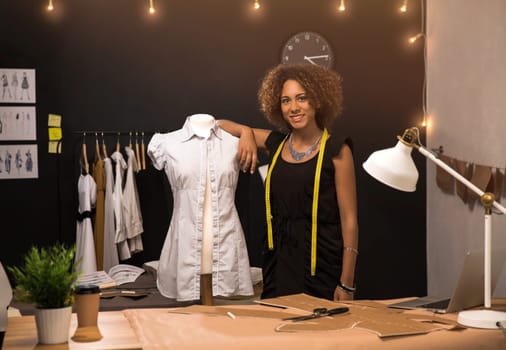 Portrait of a young fashion designer working on her atelier