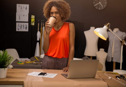 Portrait of a young fashion designer working on her atelier