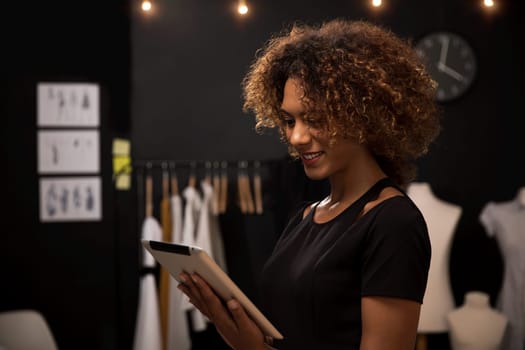 Portrait of a young fashion designer working on her atelier