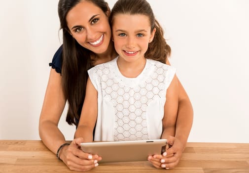 Mom teaching Daughter working with a a laptop at home