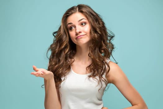 The young woman's portrait with sad emotions at studio Presenting something