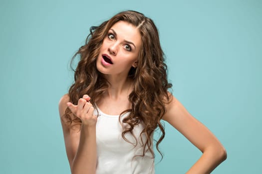 Portrait of an angry woman looking at camera isolated on a blue background