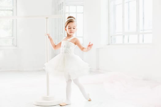 Little ballerina girl in a tutu. Adorable child dancing classical ballet in a white studio. Children dance. Kids performing. Young gifted dancer in a class. Preschool kid taking art lessons.