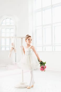 Little ballerina girl in a tutu. Adorable child dancing classical ballet in a white studio. Children dance. Kids performing. Young gifted dancer in a class. Preschool kid taking art lessons.
