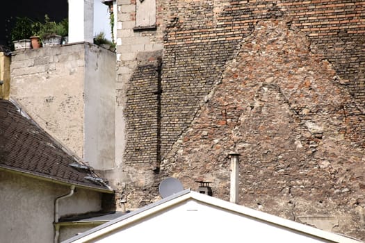 Nostalgic brick walls as well as new and old roofs in a backyard.
