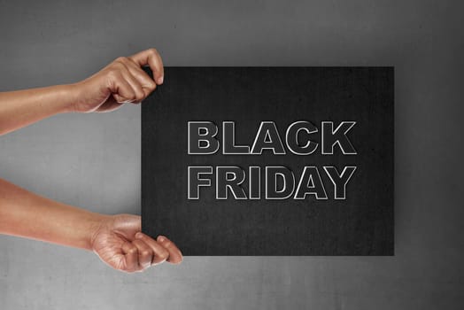 Hand holding signboard with Black Friday text. Black friday concept