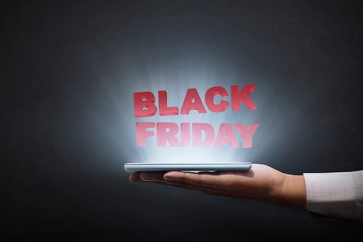 People holding tablet and showing Black Friday advert over black background