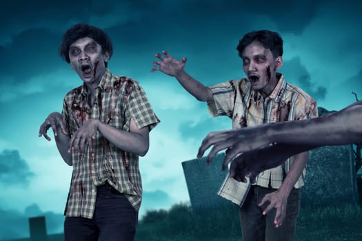Crowd of aggressive asian zombies with claw hand on the cemetery