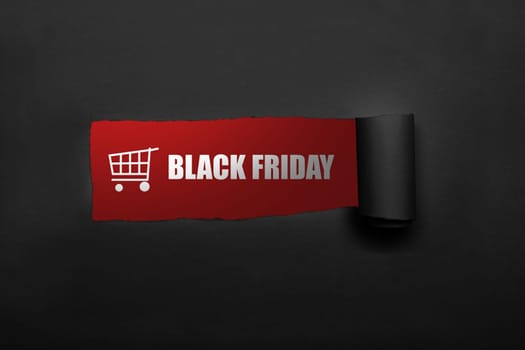 Shopping cart and Black Friday text on the paper torn
