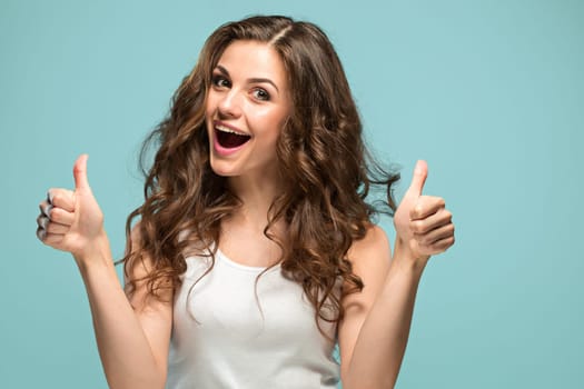 The young woman's portrait with happy emotions on gray background