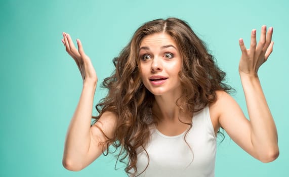 The portrait of alarmed young woman with shocked facial expression